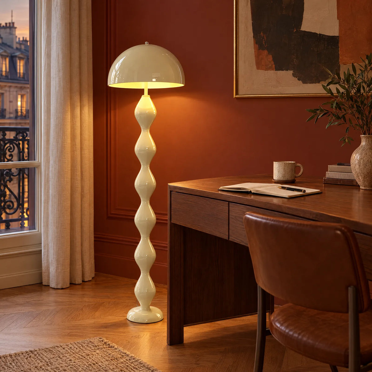 Lampadaire Laro crème allumé dans un bureau aux murs terracotta Image
