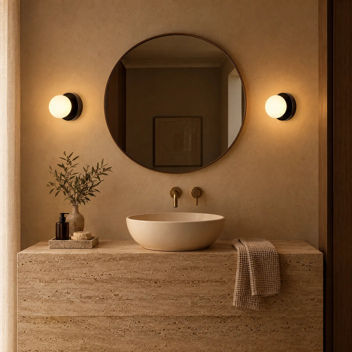 Appliques boule Olia noires allumées de part et d'autre d'un miroir de salle de bain