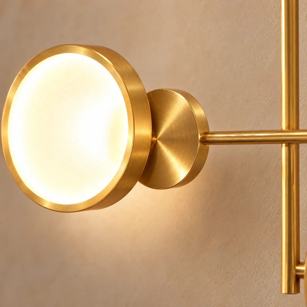 Détail d'un anneau LED allumé et d'un disque en laiton brossé de l'applique Yoka