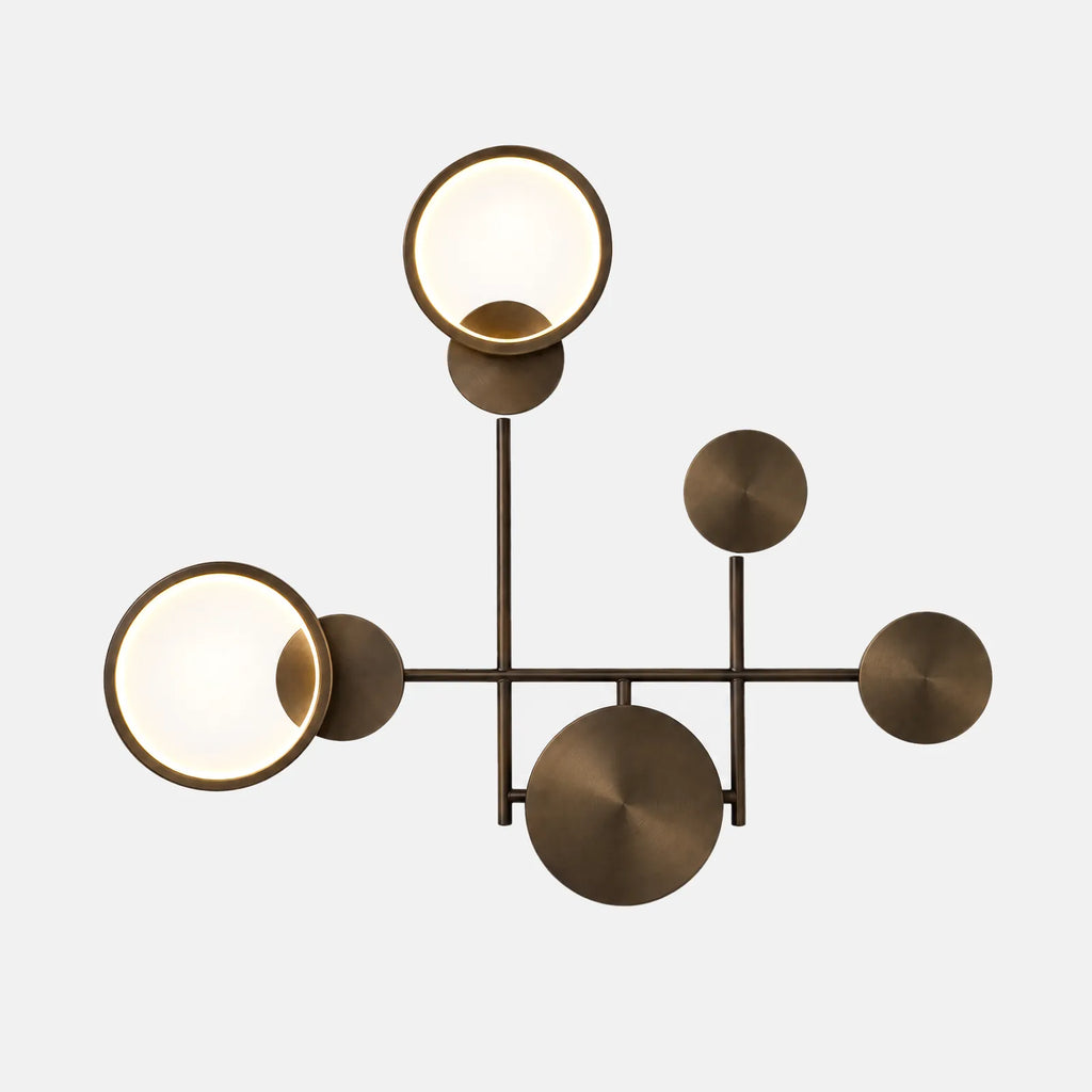 Applique murale LED Yoka noire bronze, deux anneaux lumineux et trois disques, sur fond uni