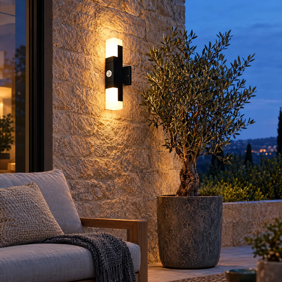 Applique extérieure Ibiza allumée sur un mur en pierre de terrasse Image