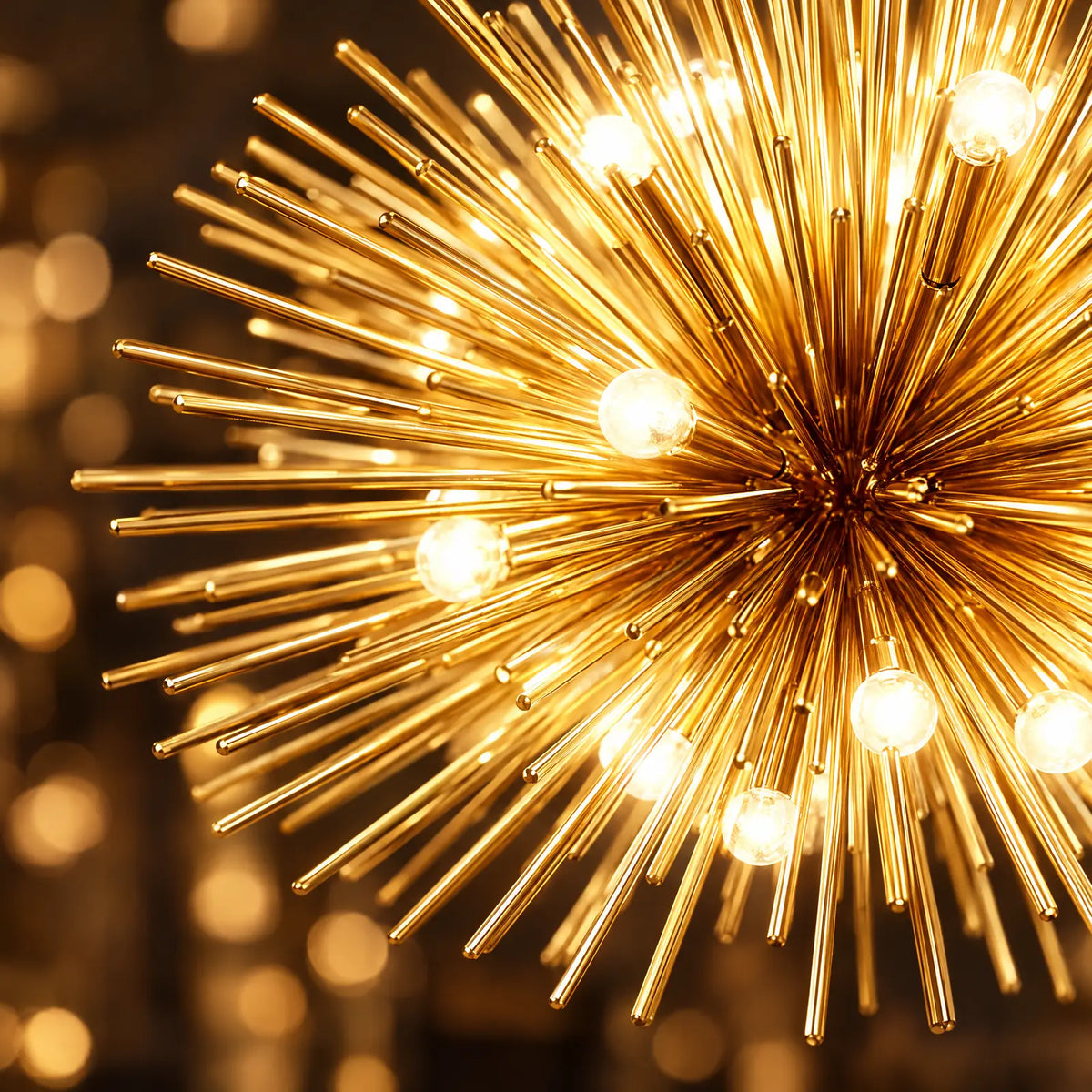 Détail des tiges dorées et des ampoules allumées du lustre Astra