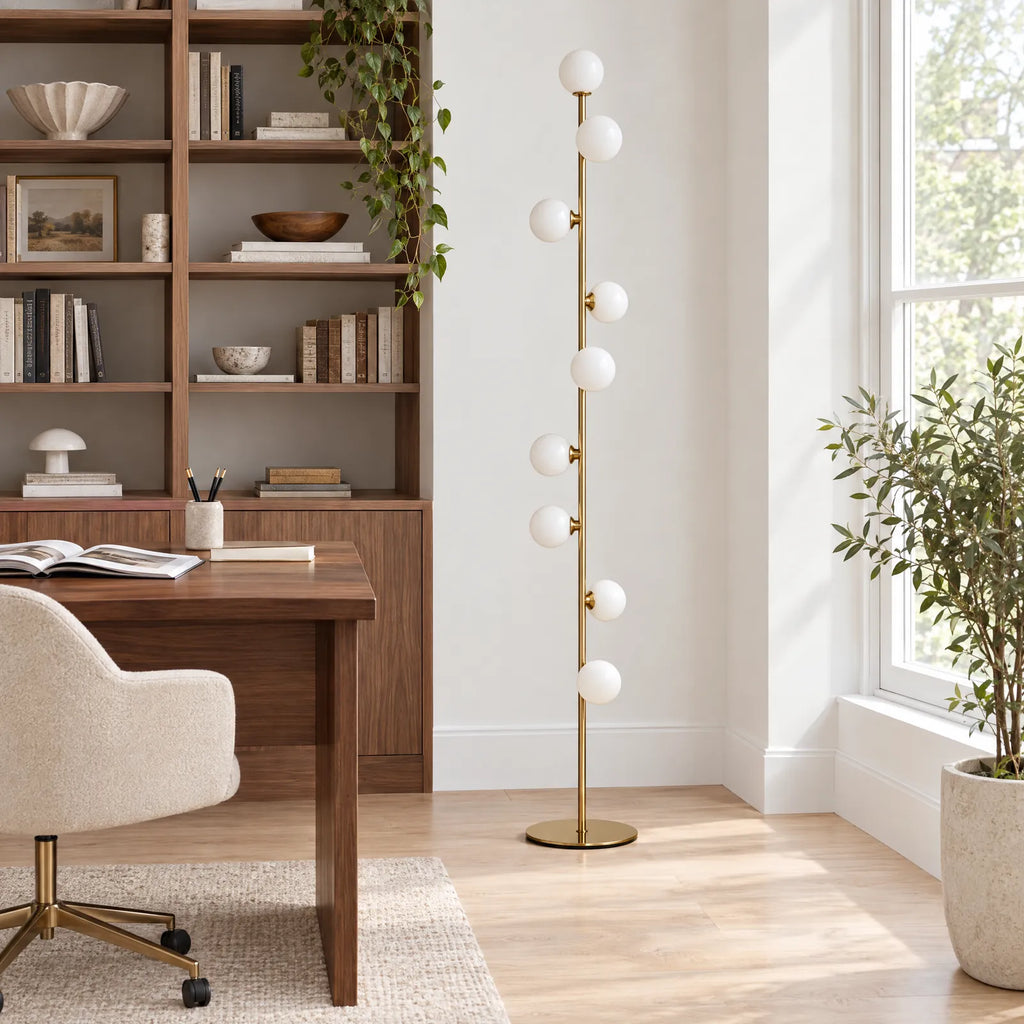 Lampadaire doré Iris à côté d'un bureau en noyer