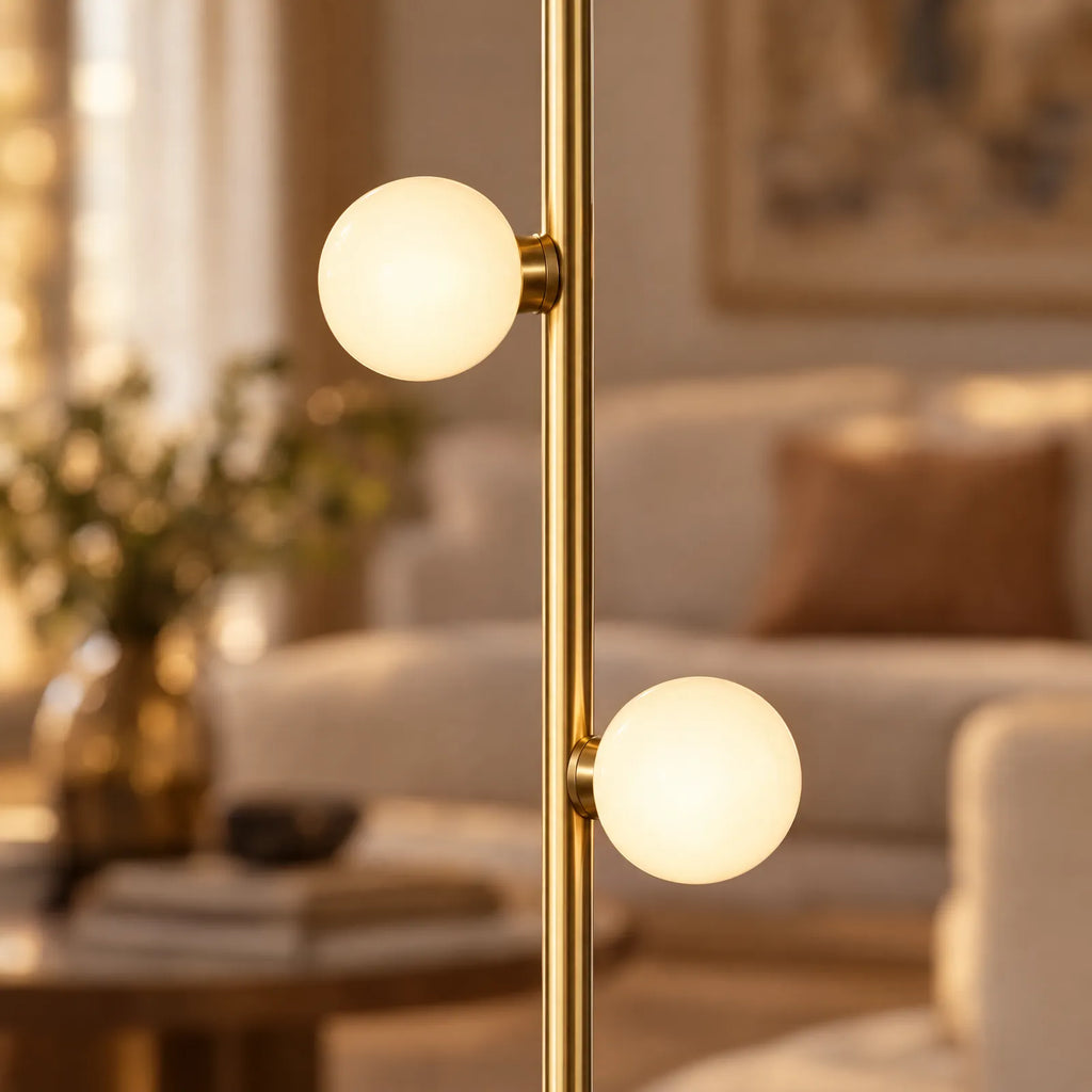 Détail des globes en verre opalin allumés sur la tige dorée du lampadaire Iris