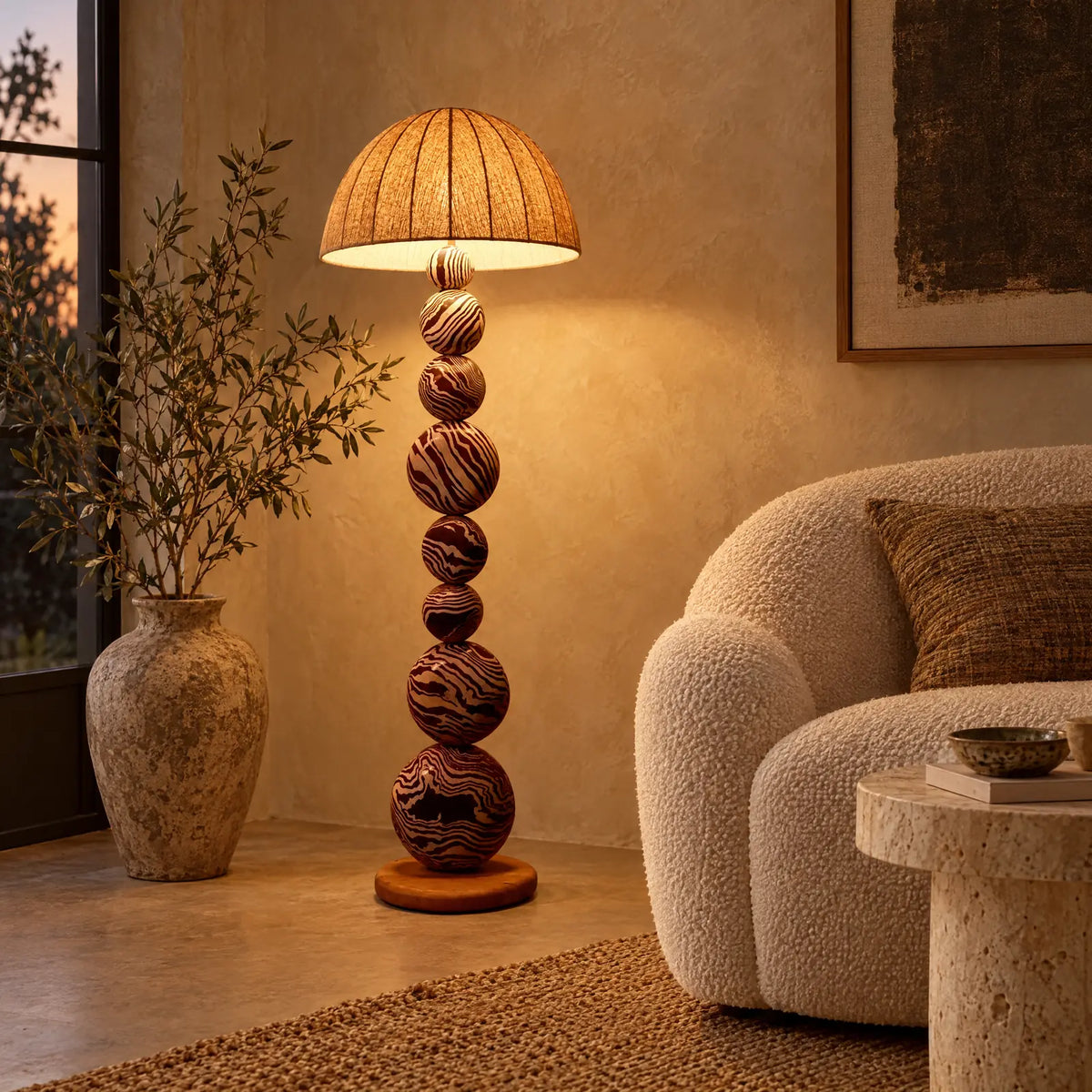 Lampadaire bohème Bali allumé à côté d'un fauteuil bouclette