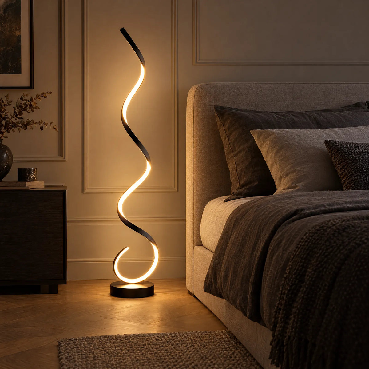 Lampadaire spirale Sofia noir allumé à côté d'un lit