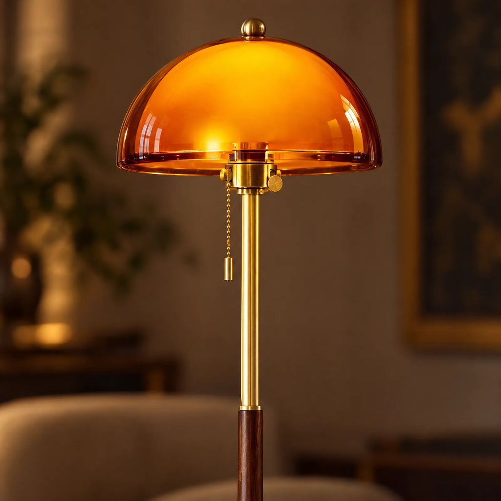 Détail du globe en verre ambré allumé et de la chaînette en laiton du lampadaire Zara