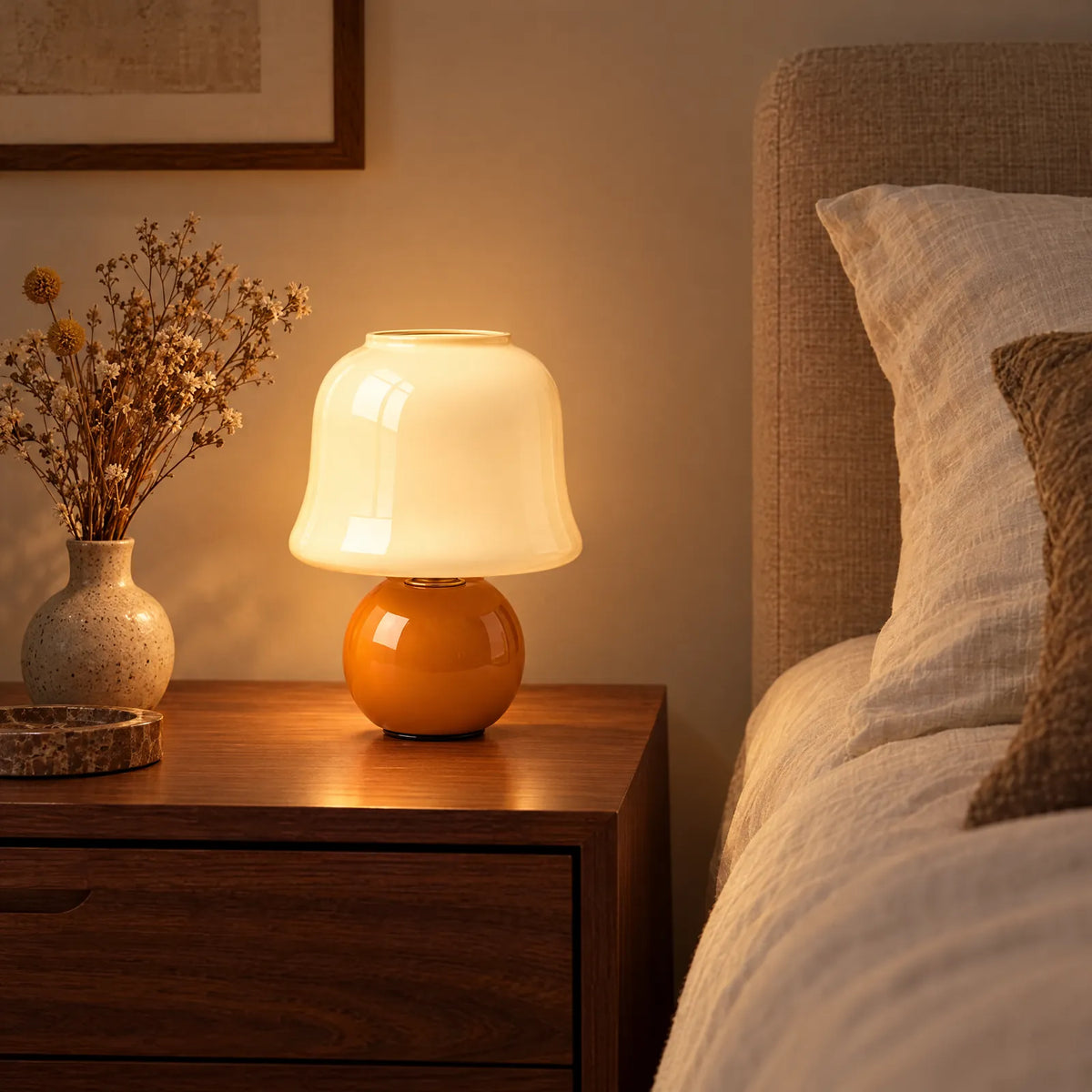 Lampe champignon Uza allumée sur une table de chevet