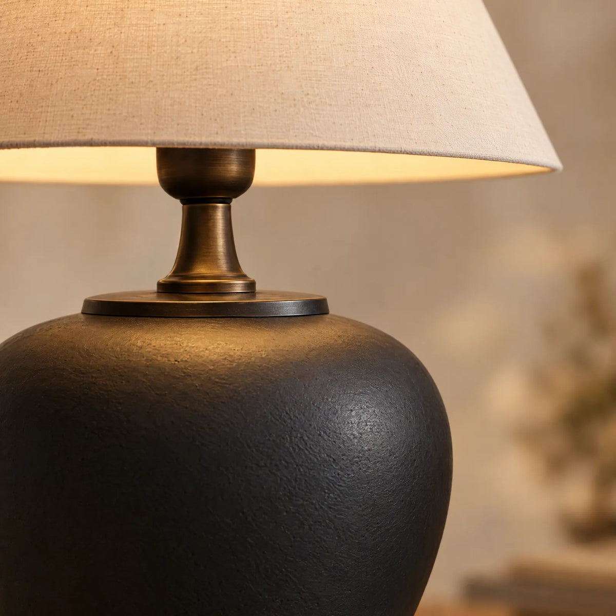 Détail de la céramique noire mate et du col en bronze de la lampe Miro