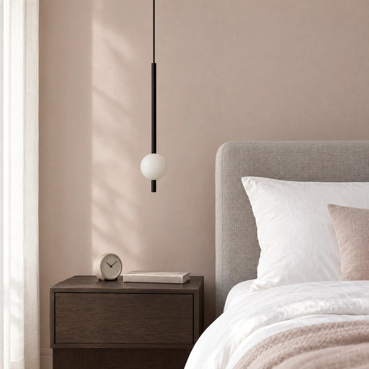 Suspension Trikka 1 lumière noire à côté d'un lit
