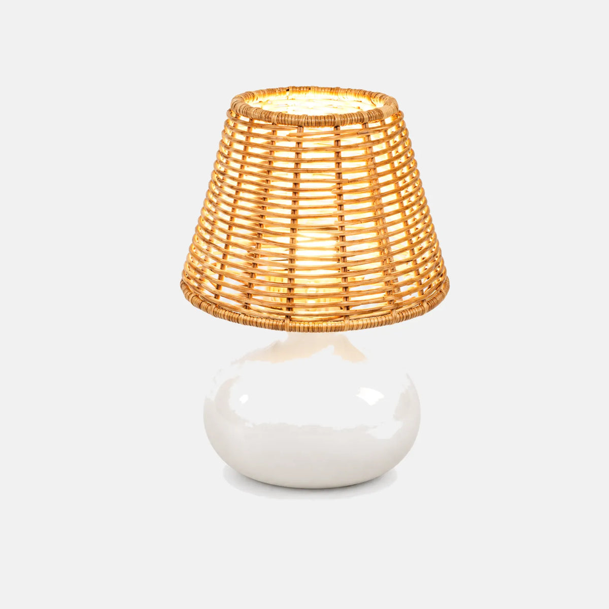 Lampe de table Kara, abat-jour en rotin tressé et pied en céramique blanche, sur fond uni