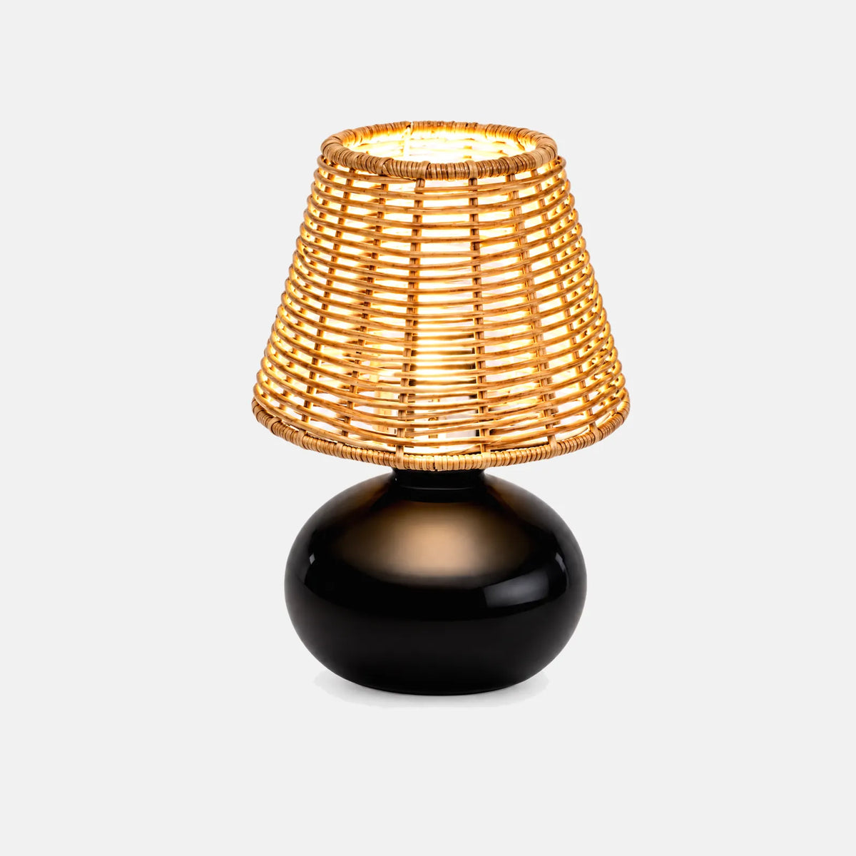 Lampe de table Kara, abat-jour en rotin tressé et pied en céramique noire, sur fond uni