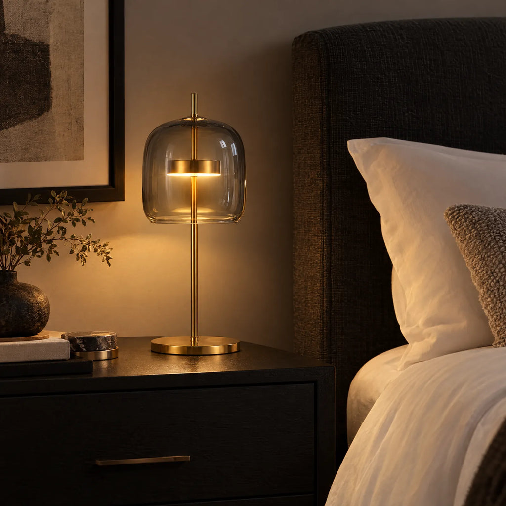 Lampe Lumio en verre gris allumée sur une table de chevet