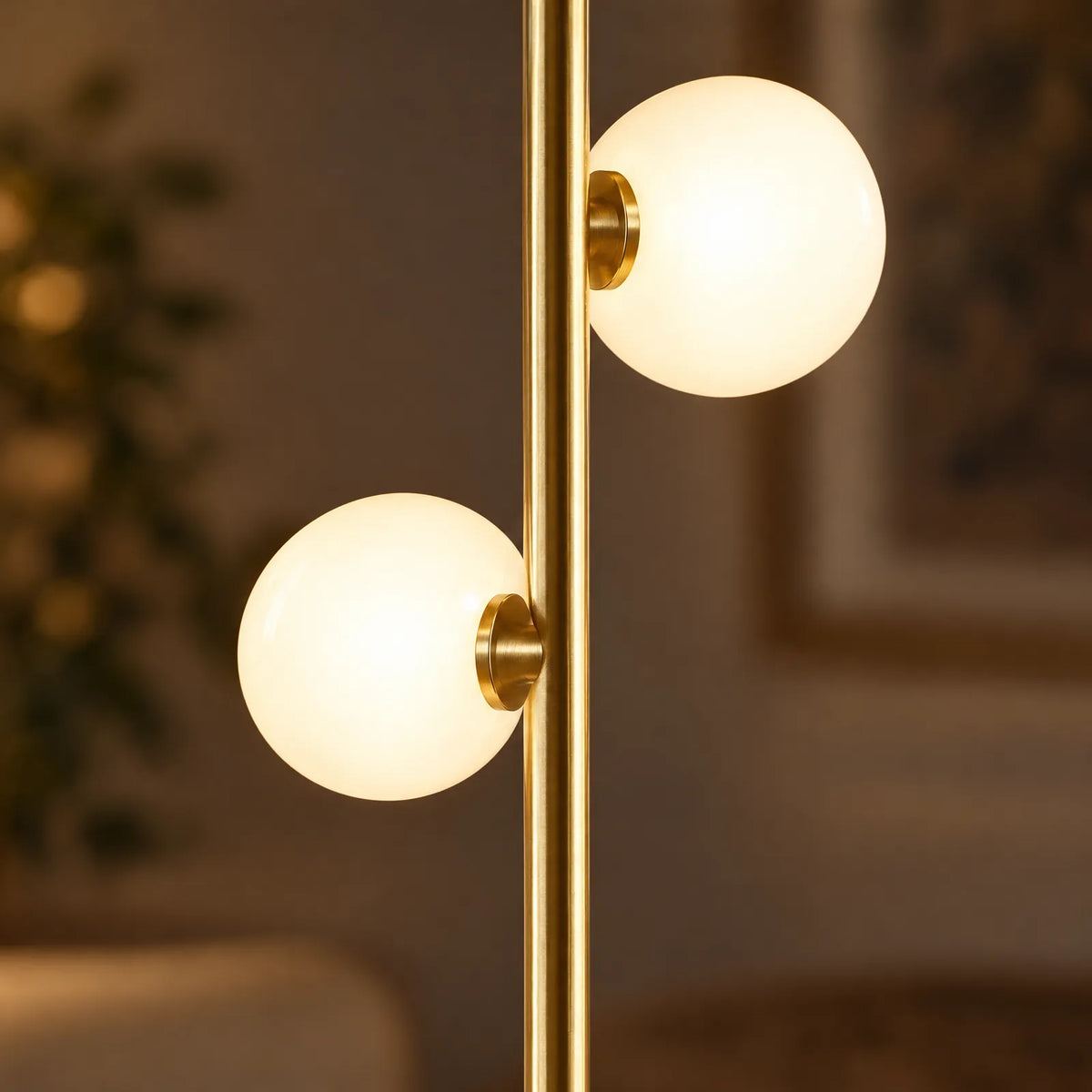 Détail des globes en verre opalin allumés et de la tige dorée du lampadaire Polia