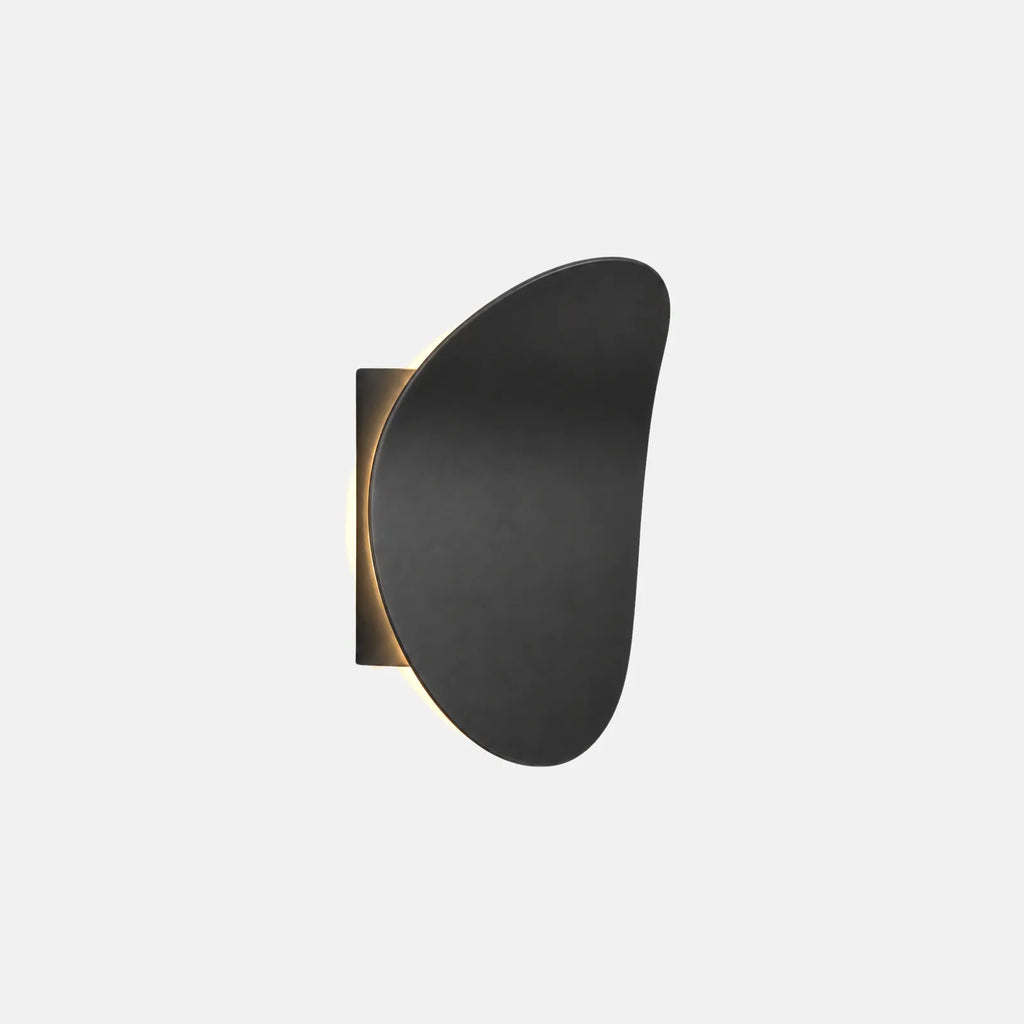Applique LED Bolio noire, disque ovale asymétrique rétroéclairé, sur fond uni