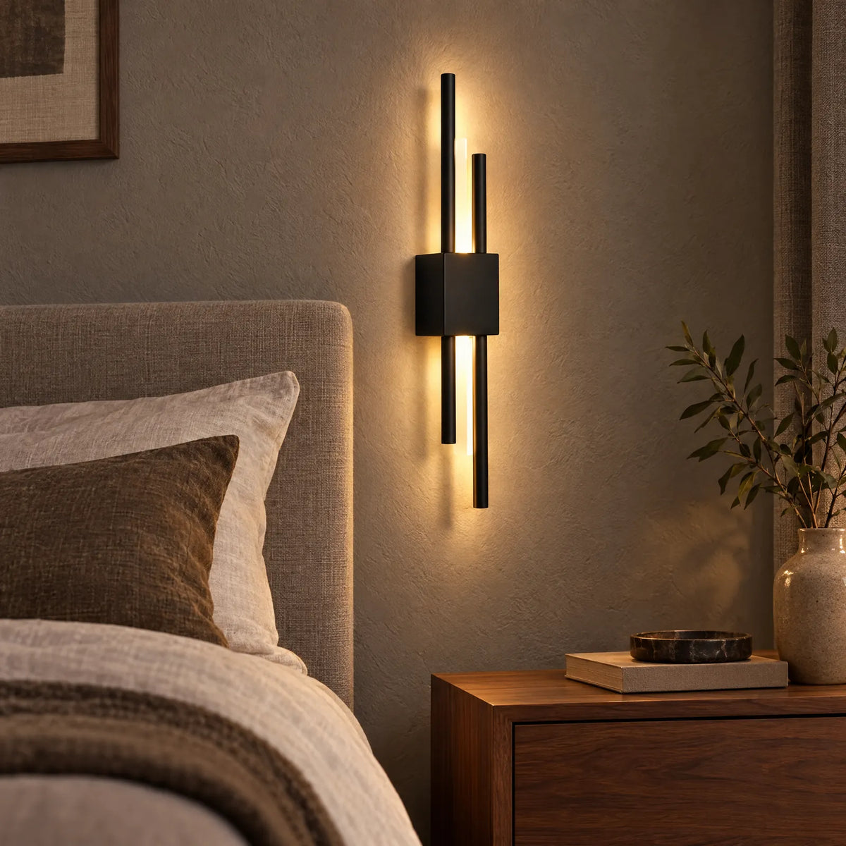 Applique LED Viva noire allumée à côté d'un lit