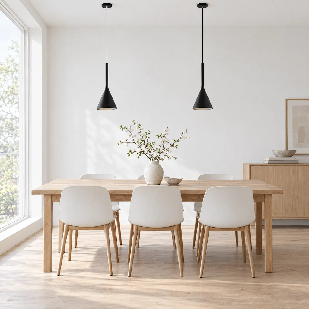 Deux suspensions Actis noires au-dessus d'une table scandinave