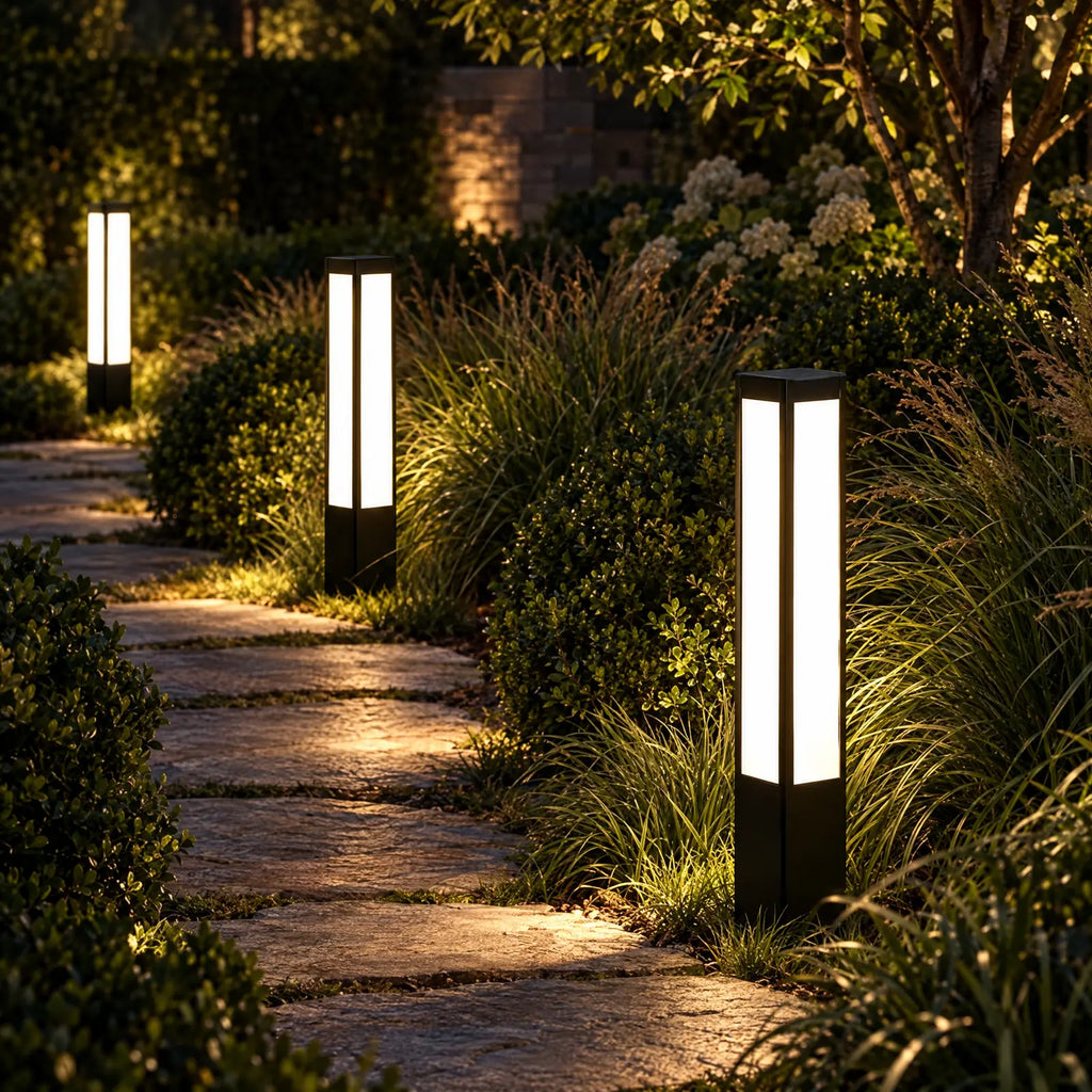Bornes solaires Suli allumées le long d'une allée de jardin la nuit