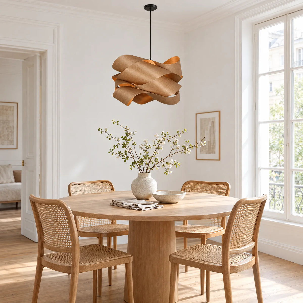 Lustre bois Boa au-dessus d'une table ronde en chêne dans une salle à manger lumineuse