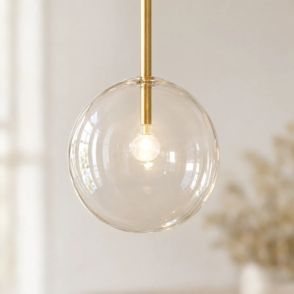 Détail du globe en verre soufflé transparent et du tube en laiton brossé de la suspension Xana