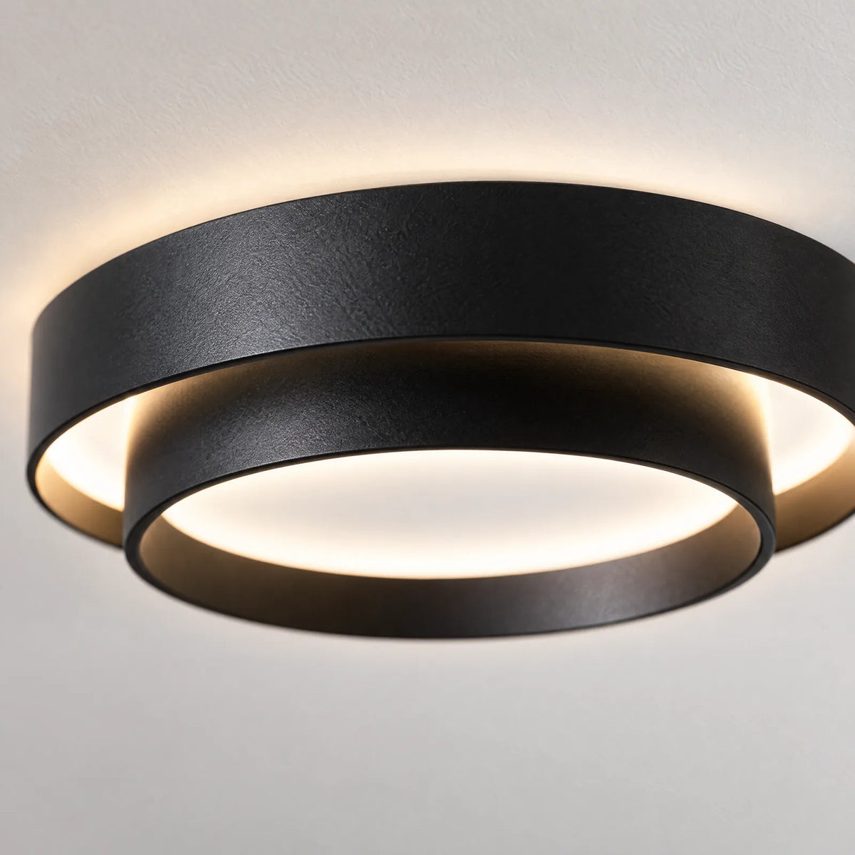 Détail des anneaux noirs et du halo lumineux du plafonnier Yalis