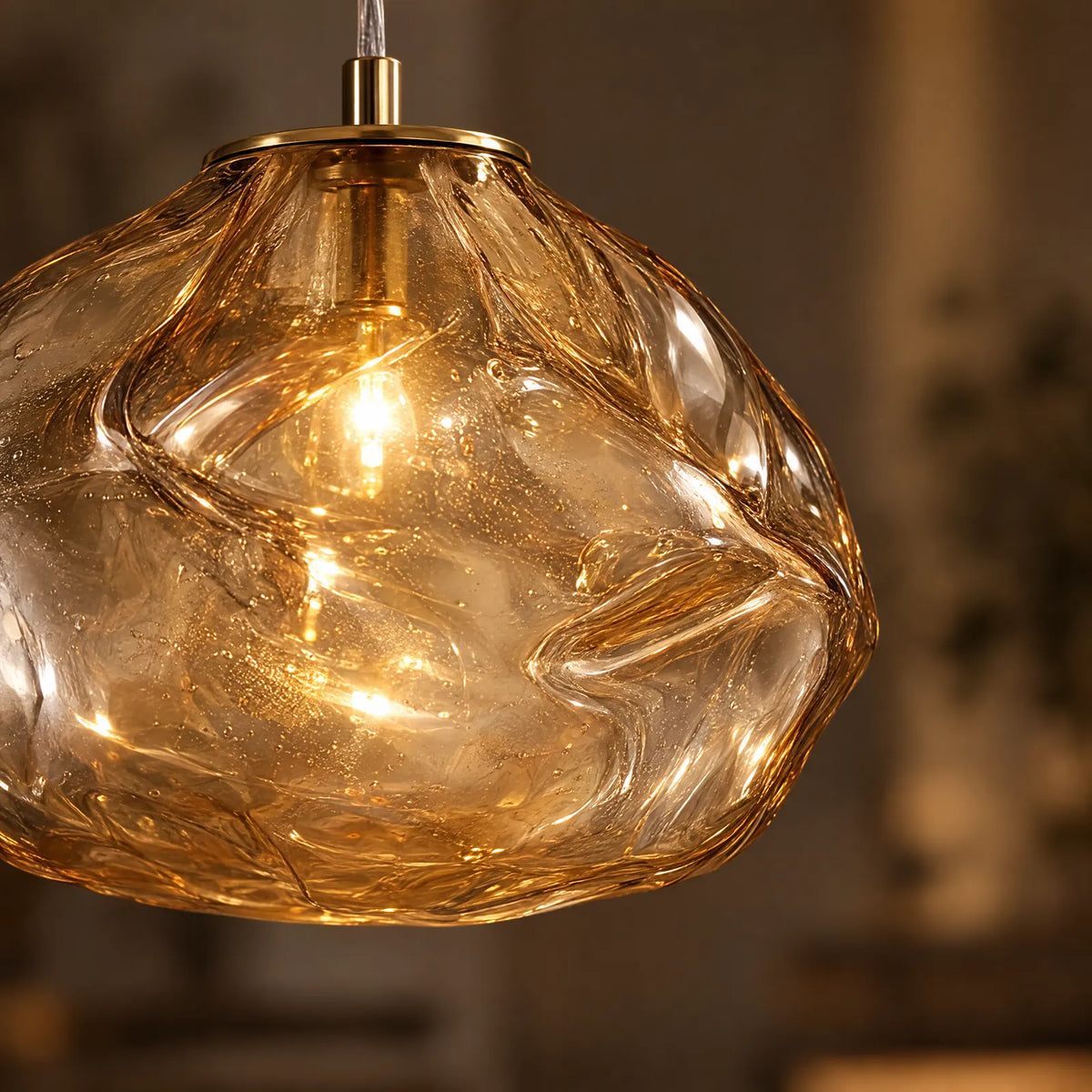 Détail des plis du verre soufflé ambré allumé de la suspension Luna