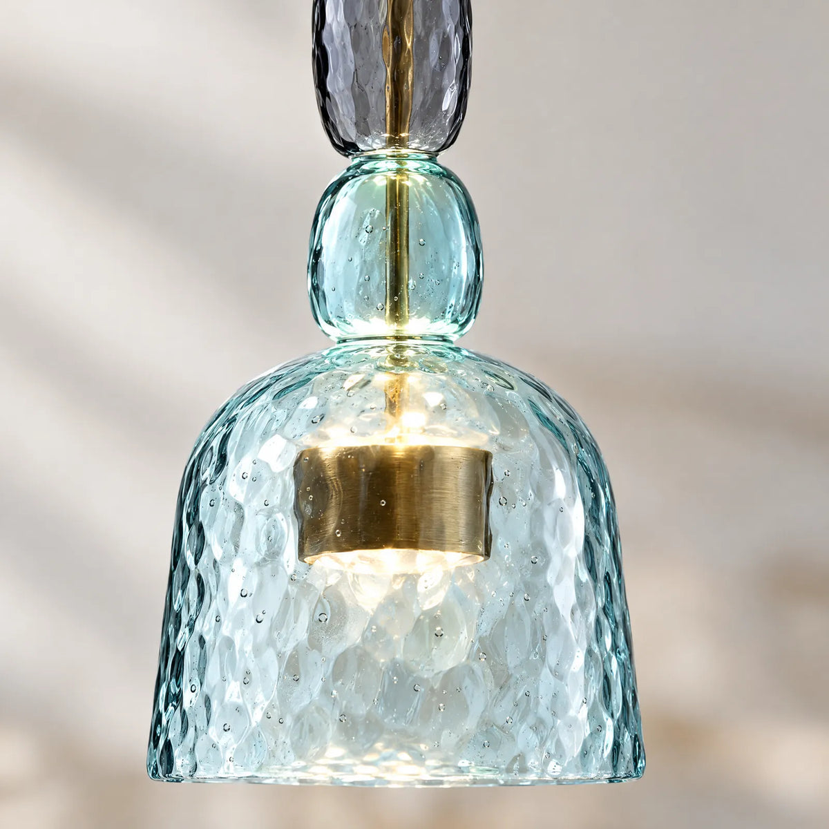 Détail du verre soufflé bleu martelé et du cylindre en laiton de la suspension Color