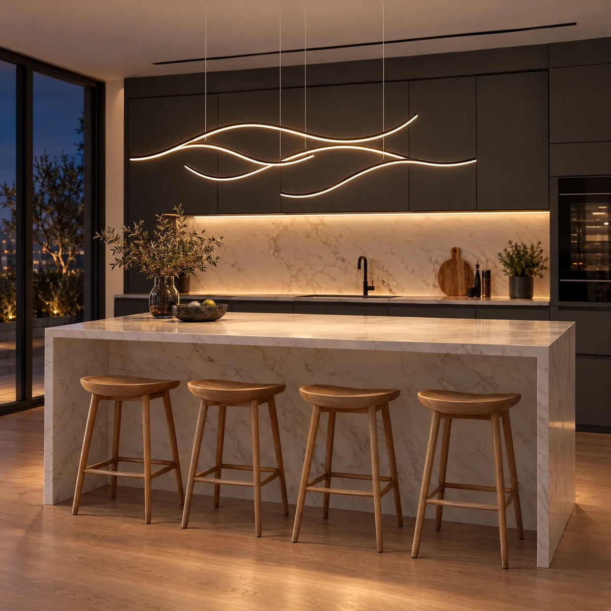 Suspension LED Arbra noire allumée au-dessus d'un îlot de cuisine en marbre Image