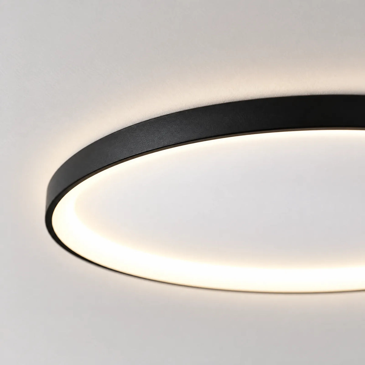 Détail du contour noir et du halo lumineux du plafonnier Nuveo