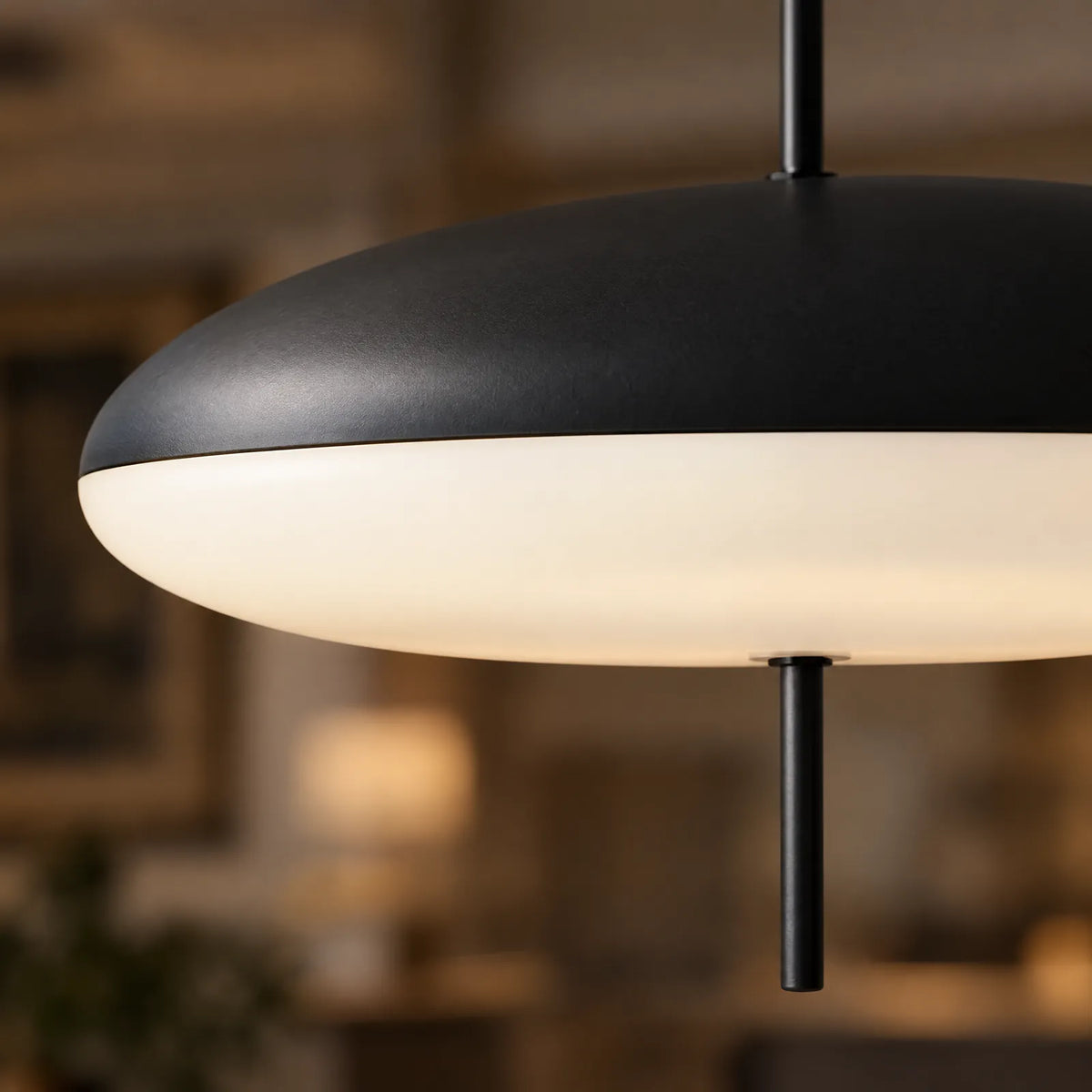 Détail du dôme noir et du diffuseur opalin allumé de la suspension Zalis