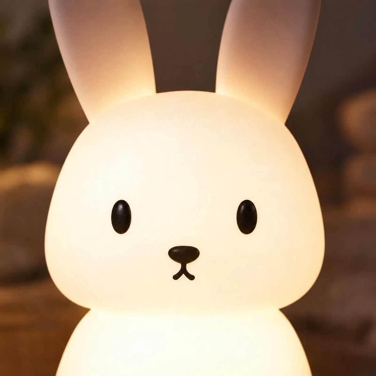 Détail du visage et des oreilles en silicone doux de la veilleuse lapin Avio